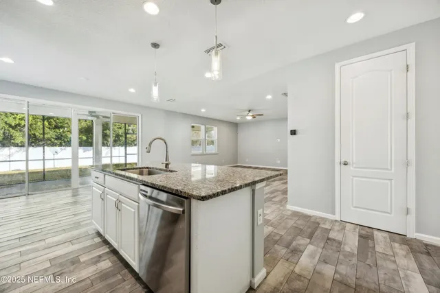 a kitchen with stainless steel appliances granite countertop a stove a sink and a microwave