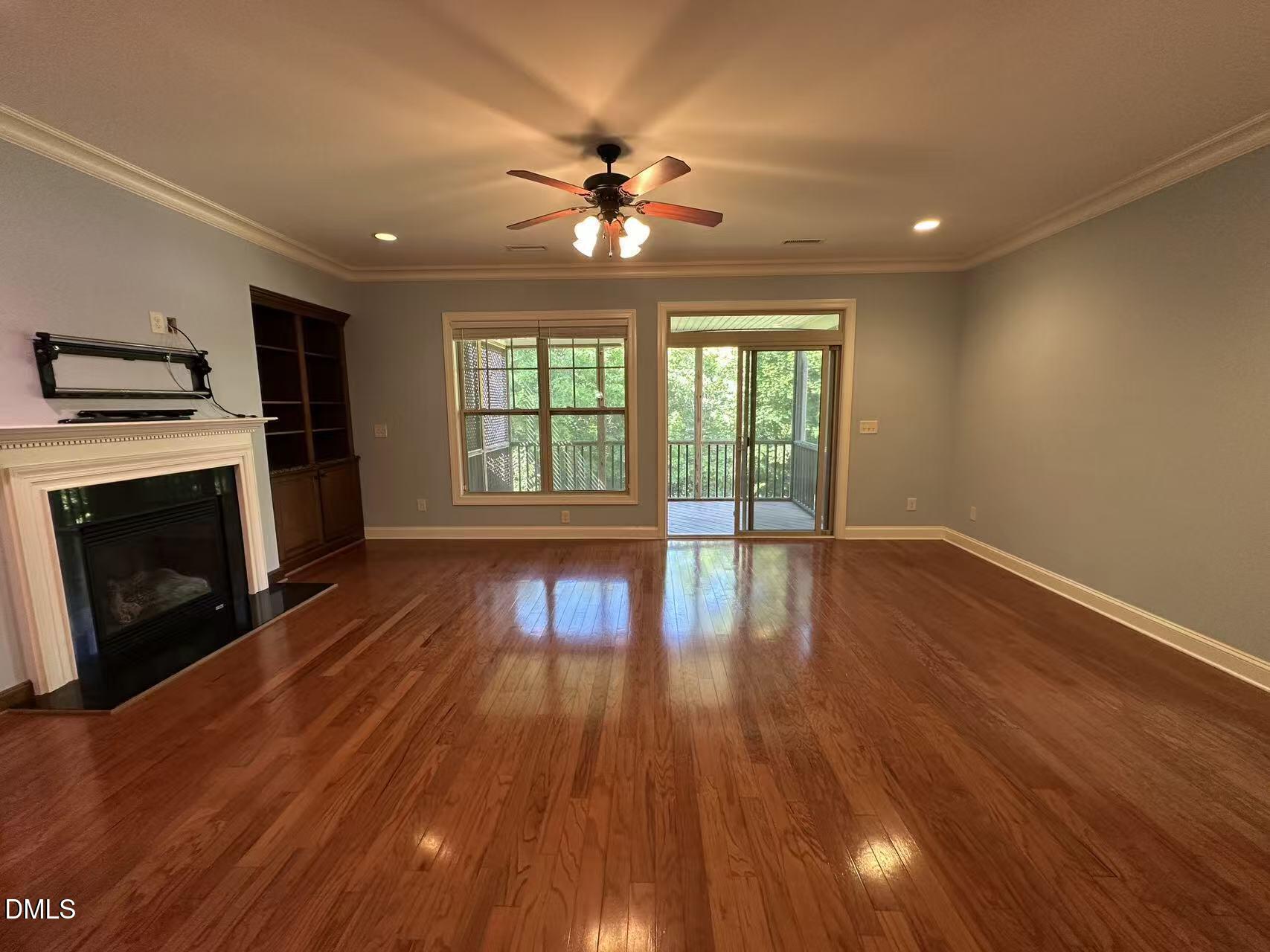 1056 Indigo Ridge Place Cary, NC 27519 - Photo 9 of 33 a view of an empty room with wooden floor and a fireplace