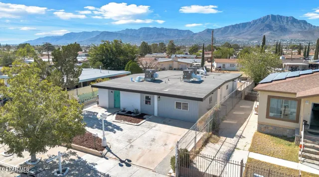 an aerial view of a house with a mountain