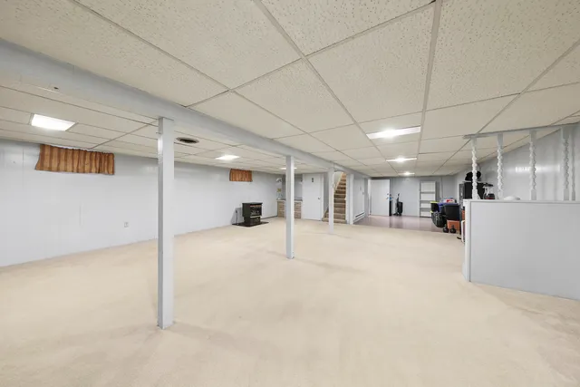 a room with stainless steel appliances kitchen island a table chairs in it and white cabinets