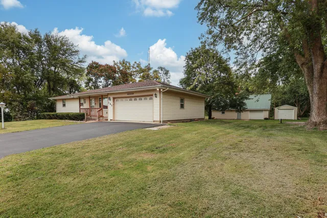 a view of a house with backyard and tree