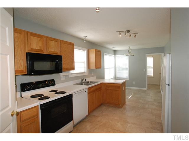 4300 Standing Rock Way Raleigh, NC 27604 - Photo 4 of 12 Spacious Kitchen & Dining Area with New Ceramic Tile Flooring, Lighting, Microwave & Faucet. Kitchen also features an Electric Stove, Dishwasher & Walk-in Pantry Closet. The Spacious Laundry Room is past the Dining Area and has access to the 2-Car Garage