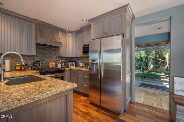 a kitchen with granite countertop a sink stove and cabinets
