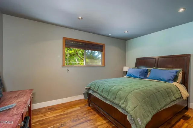 a bedroom with a bed table and dresser