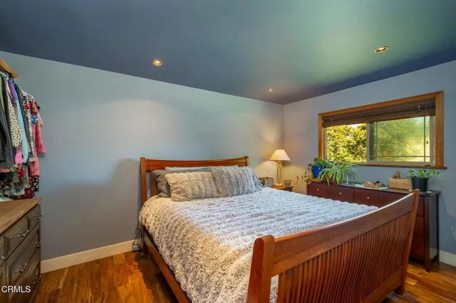 a bedroom with a bed a mirror and dresser