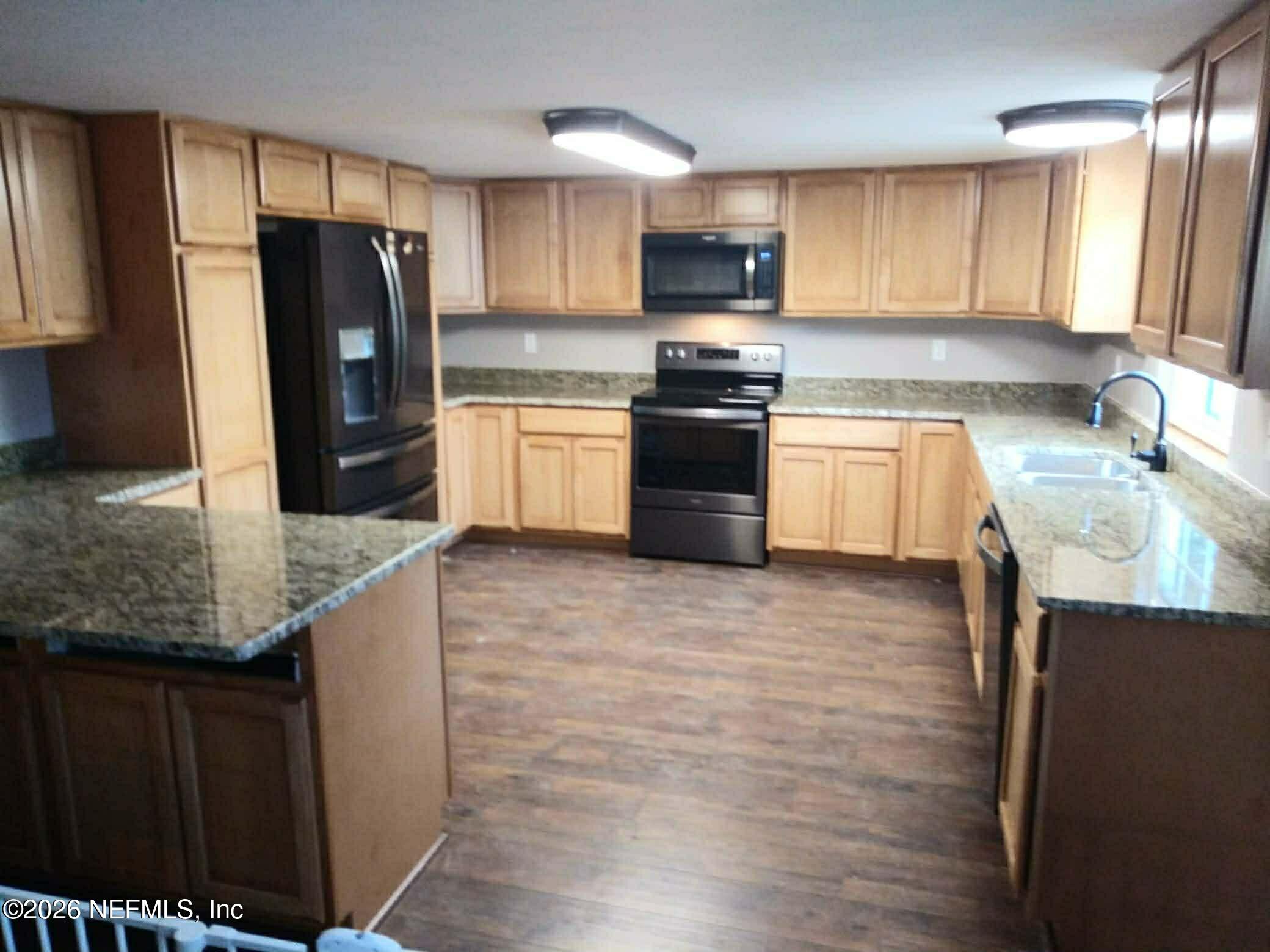 6319 Bucknell Avenue Keystone Heights, FL 32656 - Photo 7 of 11 a kitchen with stainless steel appliances granite countertop a refrigerator sink and stove