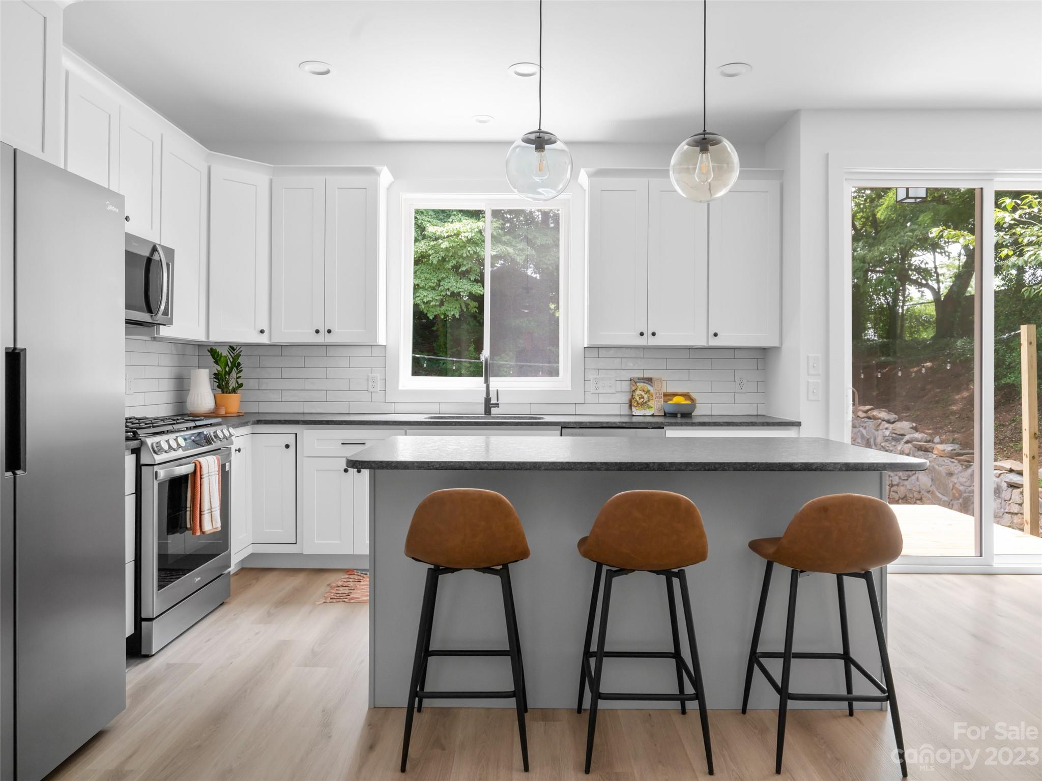 67 Raleigh Road Asheville, NC 28803 - Photo 14 of 43 a kitchen with stainless steel appliances granite countertop a stove a sink island and a refrigerator