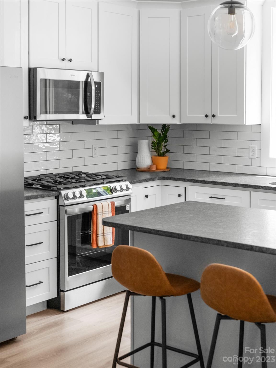67 Raleigh Road Asheville, NC 28803 - Photo 18 of 43 a kitchen with stainless steel appliances a stove a sink cabinets and a window