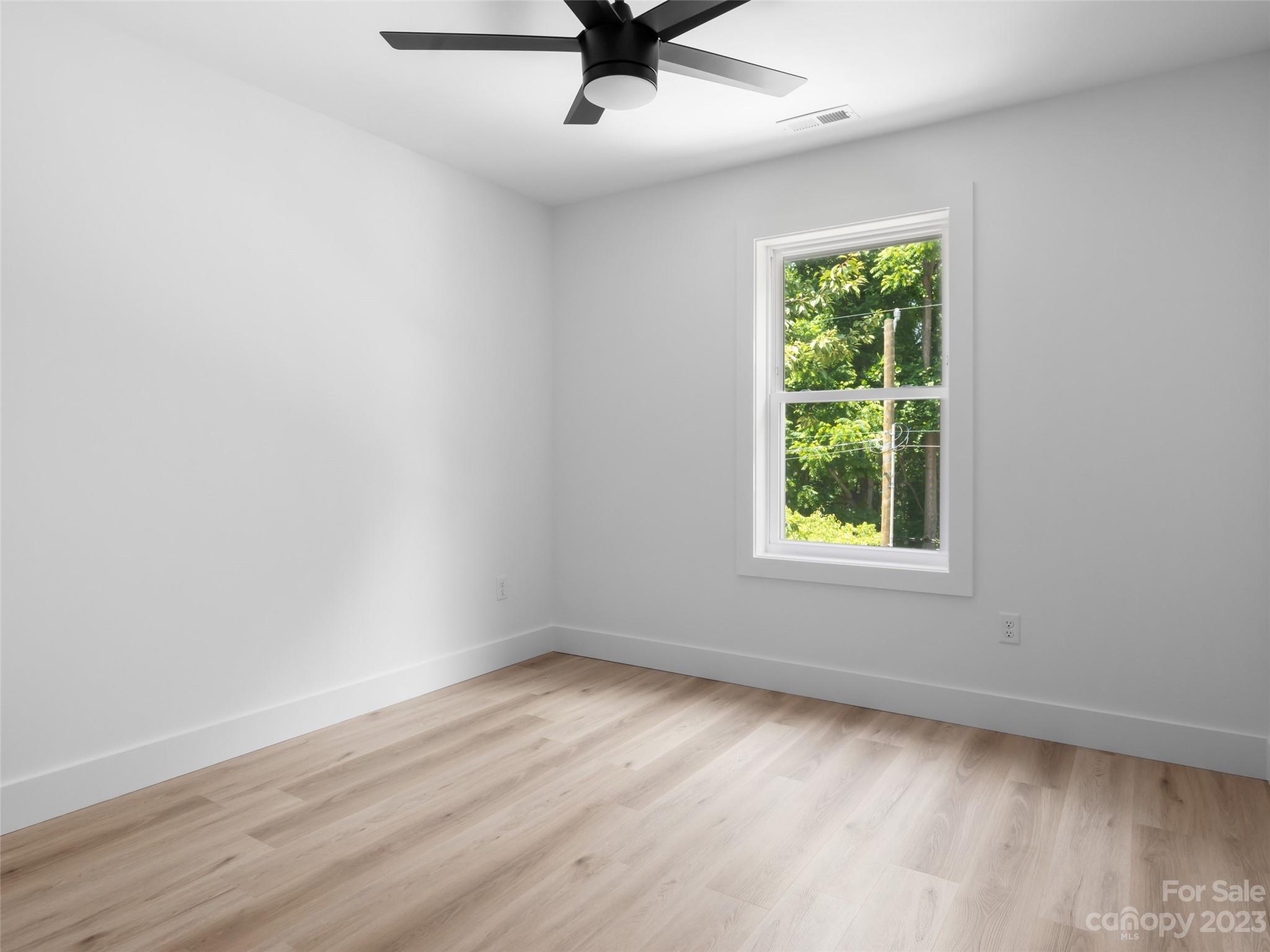 67 Raleigh Road Asheville, NC 28803 - Photo 32 of 43 an empty room with wooden floor and windows