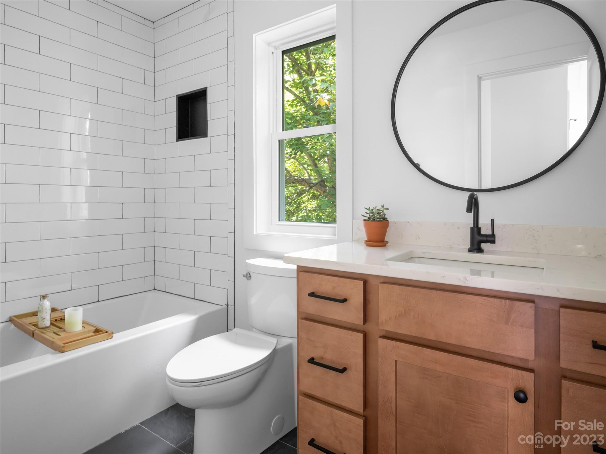 67 Raleigh Road Asheville, NC 28803 - Photo 33 of 43 a bathroom with a toilet a sink a mirror and bathtub