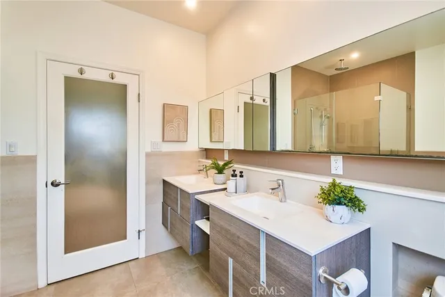 a bedroom with a bed and a computer on the desk next to a window