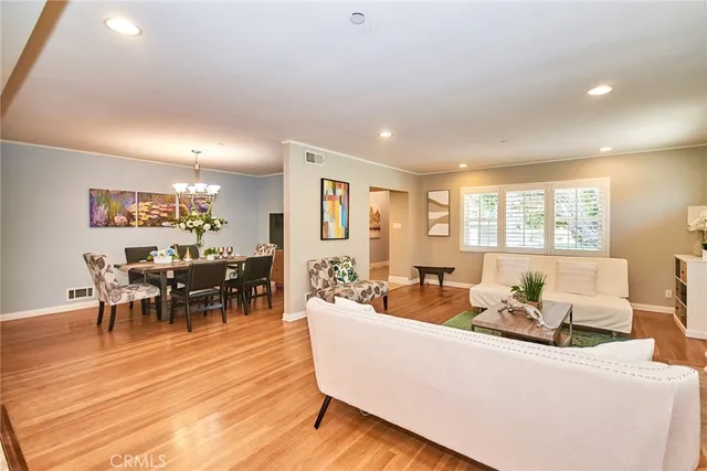 a view of a dining room with furniture a chandelier and wooden floor