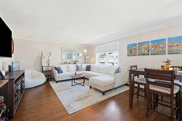a living room with furniture wooden floor and a flat screen tv
