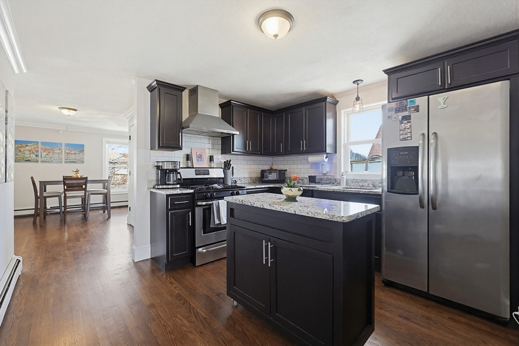 48 Calumet Street, Unit 2 Revere, MA 02151 - Photo 8 of 30 a kitchen with stainless steel appliances granite countertop a refrigerator a stove top oven a sink dishwasher and white cabinets with wooden floor