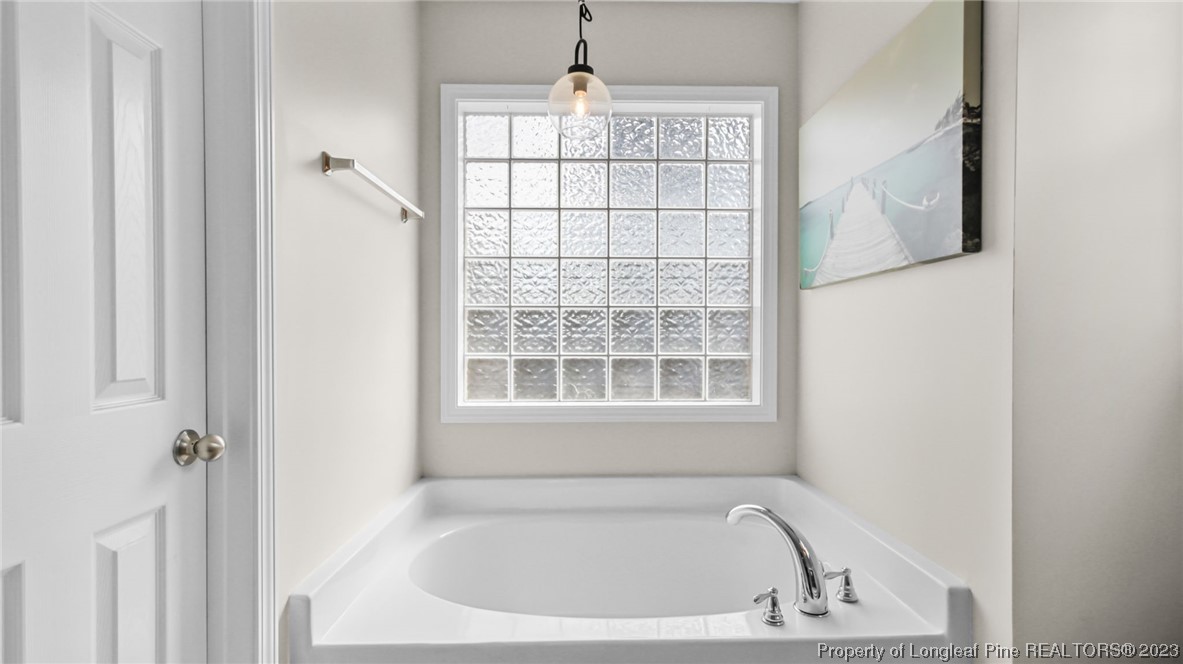 2219 Gray Goose Loop Fayetteville, NC 28306 - Photo 27 of 36 a white bath tub sitting next to a window
