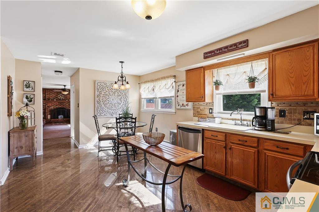 49 South Rhoda Street Monroe Township, NJ 08831 - Photo 4 of 11 a kitchen with stainless steel appliances granite countertop a stove a refrigerator a sink dishwasher and a dining table with wooden floor