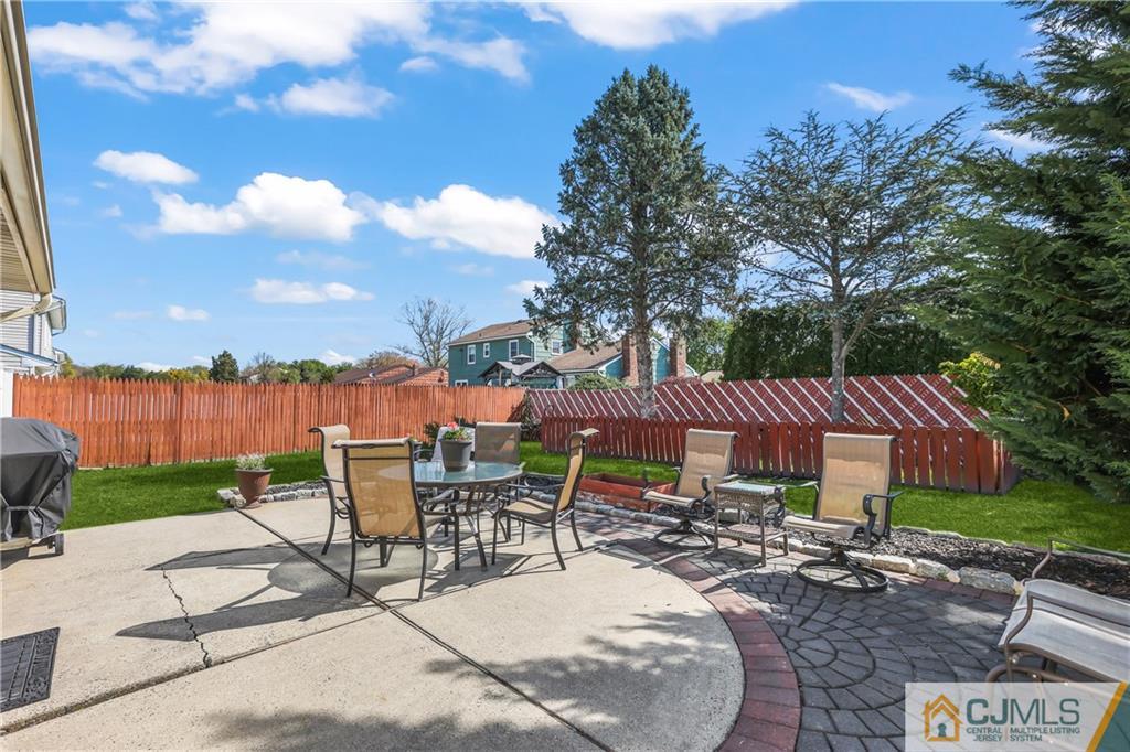 49 South Rhoda Street Monroe Township, NJ 08831 - Photo 6 of 11 a view of a patio with table and chairs under an umbrella