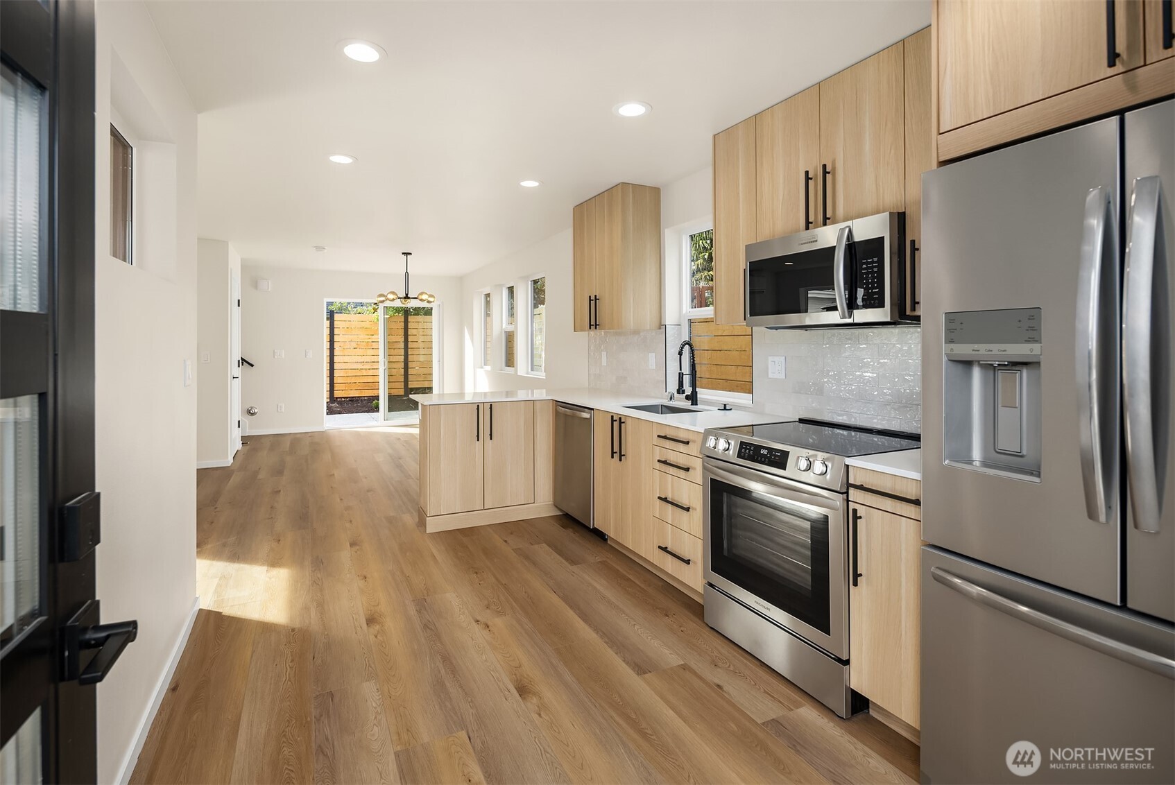 6503 Dibble Avenue Northwest Seattle, WA 98117 - Photo 2 of 15 a kitchen with stainless steel appliances a refrigerator sink and microwave