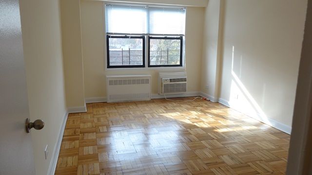 59-17 Junction Boulevard, Unit 3J Queens, NY 11368 - Photo 4 of 5 a view of an empty room with a window