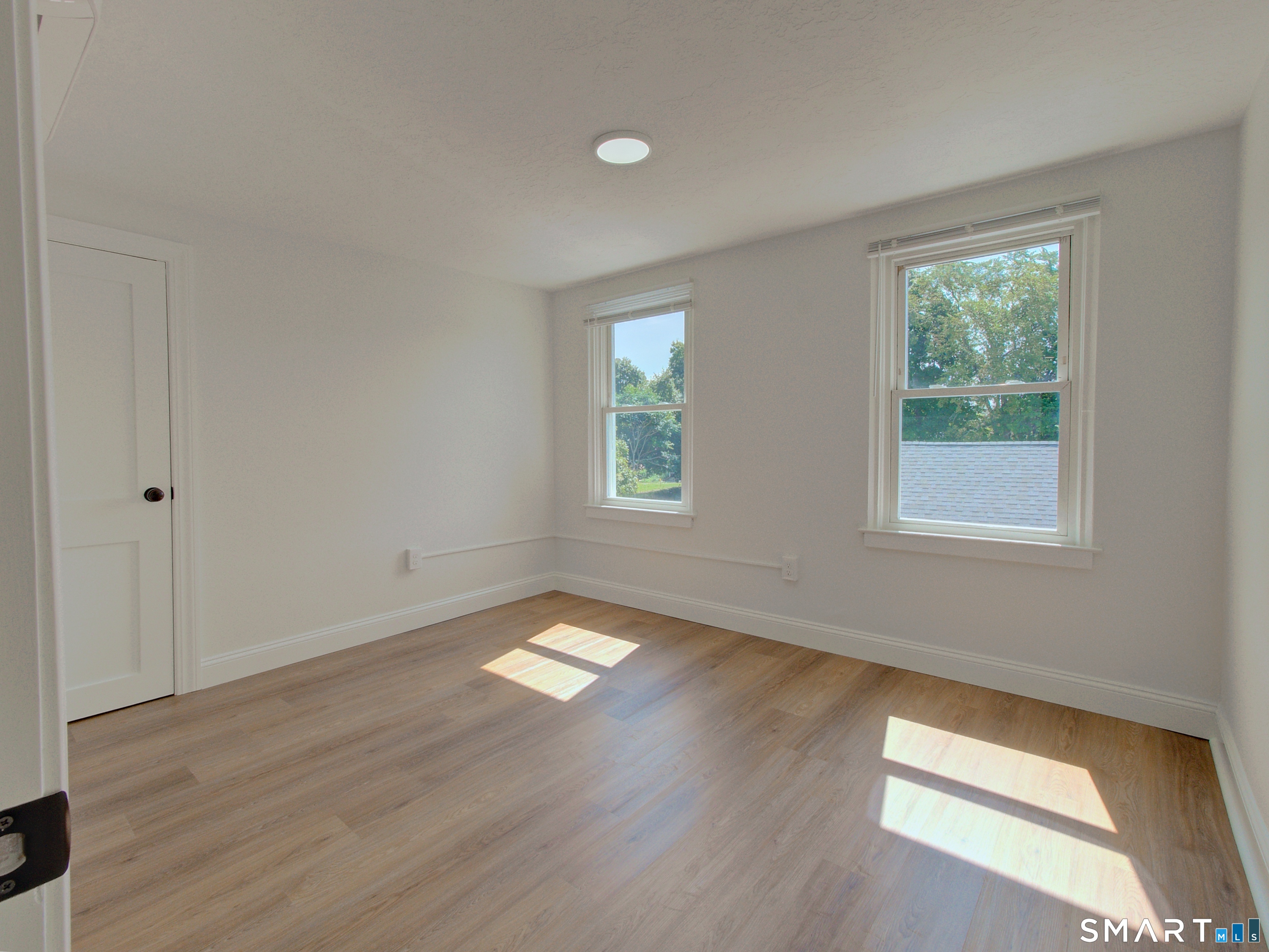 16 Benham Road, Unit D Groton, CT 06340 - Photo 12 of 15 a view of an empty room with wooden floor and a window