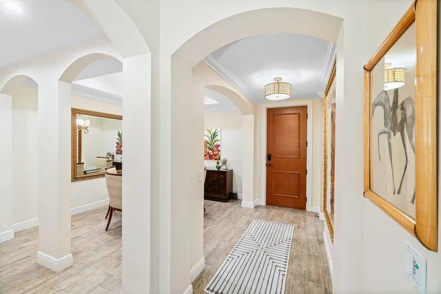 a view of a hallway with wooden floor and a living room
