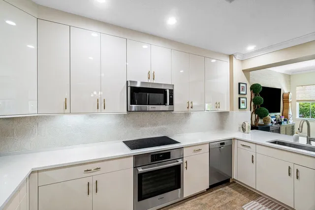 a kitchen with granite countertop white cabinets and white appliances