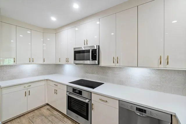 a kitchen with white cabinets and white appliances