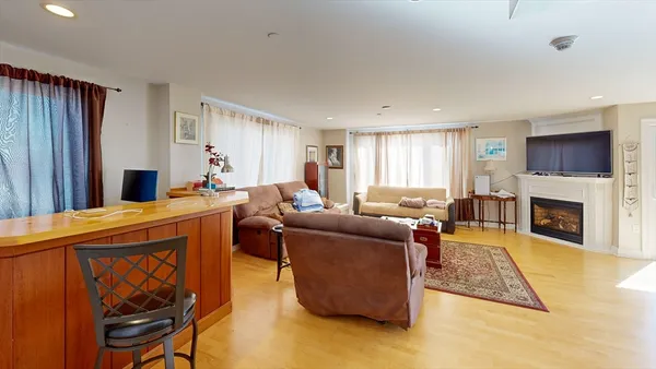 a living room with furniture a flat screen tv and a fireplace