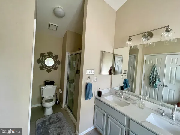 a bathroom with a granite countertop sink a toilet and shower