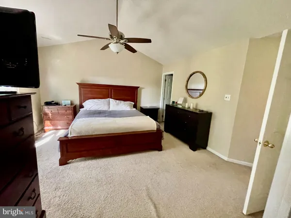 a bedroom with a bed and a flat tv screen on dresser