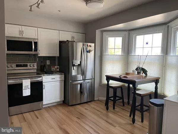 a kitchen with granite countertop a refrigerator stove and microwave