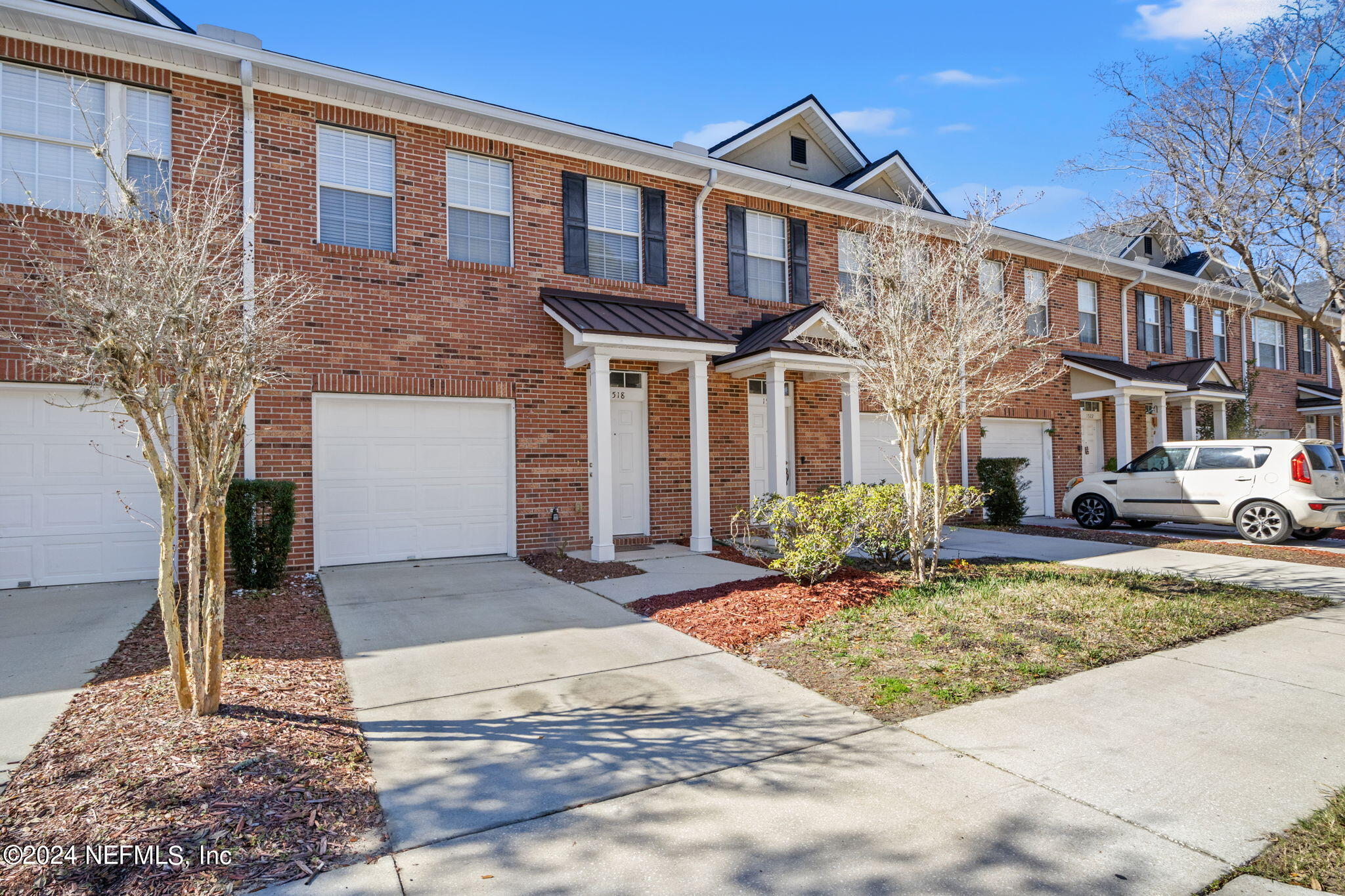 a front view of a building with cars parked