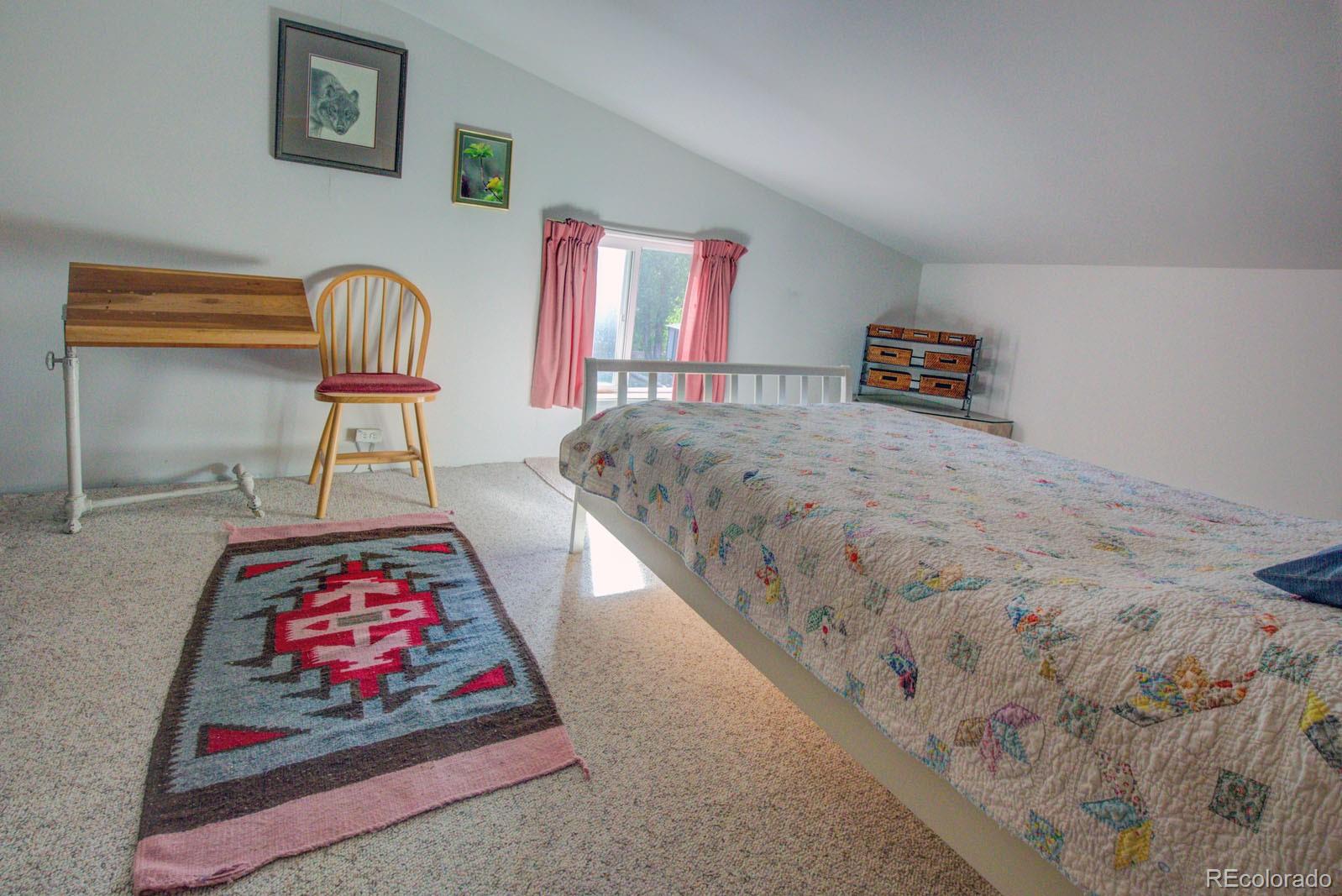 203 Hampton Run Road Mosca, CO 81146 - Photo 24 of 33 a living room with rug couches cushion and a window