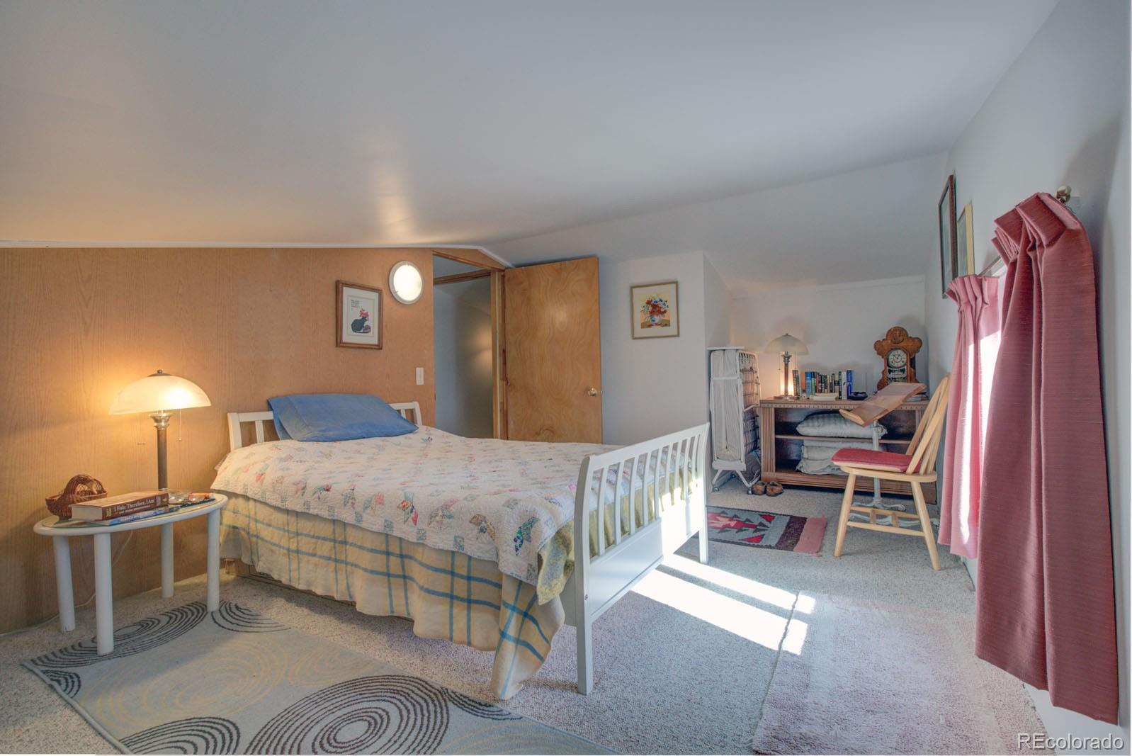 203 Hampton Run Road Mosca, CO 81146 - Photo 25 of 33 a bedroom with a bed and a lamp