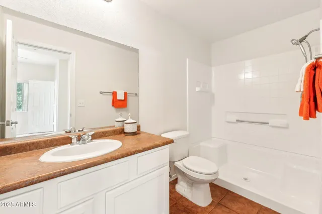 a bathroom with a granite countertop sink toilet a mirror and shower