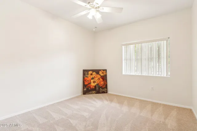 an empty room with windows and fan