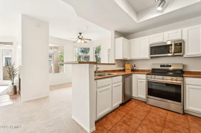 a kitchen with stainless steel appliances granite countertop a refrigerator a stove top oven a sink and dishwasher