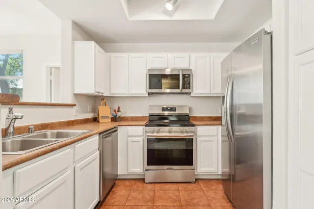 a kitchen with cabinets stainless steel appliances and a sink