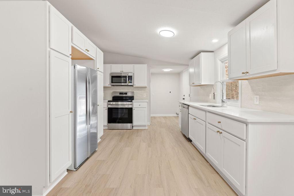 10022 Kentucky Springs Road Mineral, VA 23117 - Photo 12 of 31 a large kitchen with cabinets wooden floor and stainless steel appliances