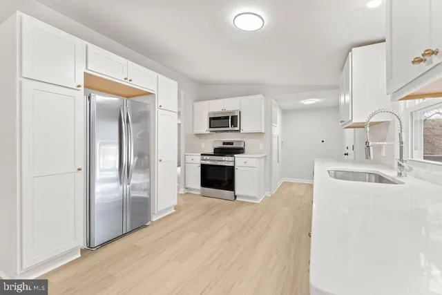 a kitchen with granite countertop a refrigerator and a sink