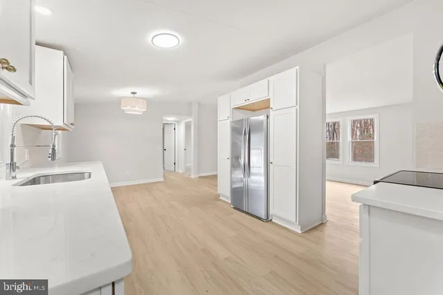a view of a kitchen with a sink and a refrigerator