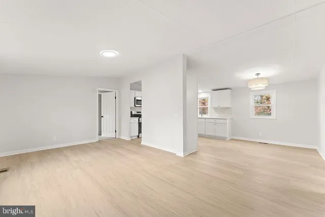 an empty room with windows and wooden floor