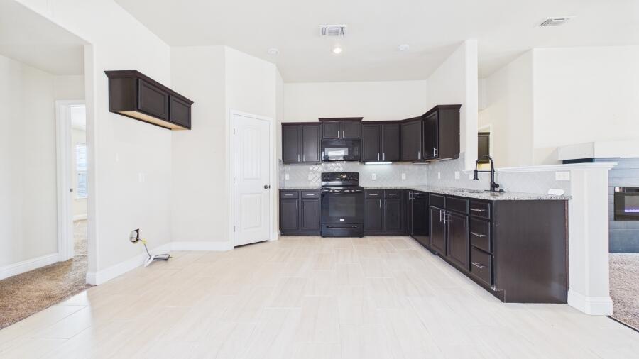 3707 Rochester Avenue Lubbock, TX 79407 - Photo 14 of 40 a kitchen with a sink and a refrigerator