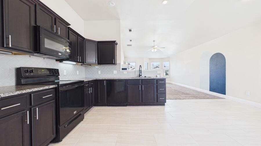 3707 Rochester Avenue Lubbock, TX 79407 - Photo 16 of 40 a kitchen with stainless steel appliances granite countertop a sink stove and microwave