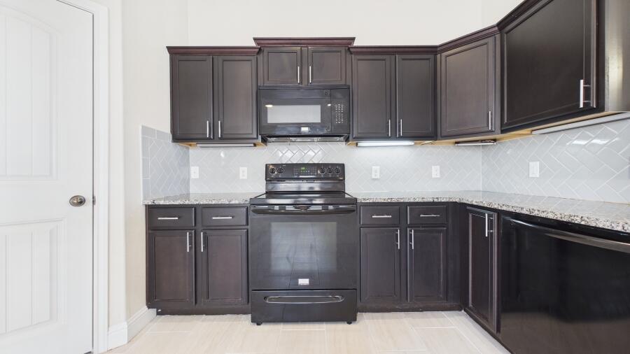 3707 Rochester Avenue Lubbock, TX 79407 - Photo 17 of 40 a kitchen with stainless steel appliances granite countertop wooden cabinets a stove top oven and granite counter tops