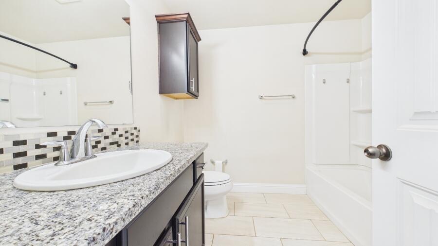 3707 Rochester Avenue Lubbock, TX 79407 - Photo 23 of 40 a bathroom with a granite countertop sink and a mirror