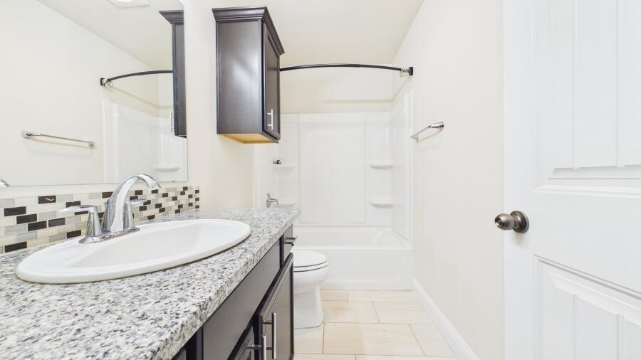 3707 Rochester Avenue Lubbock, TX 79407 - Photo 39 of 40 a bathroom with a sink and a mirror