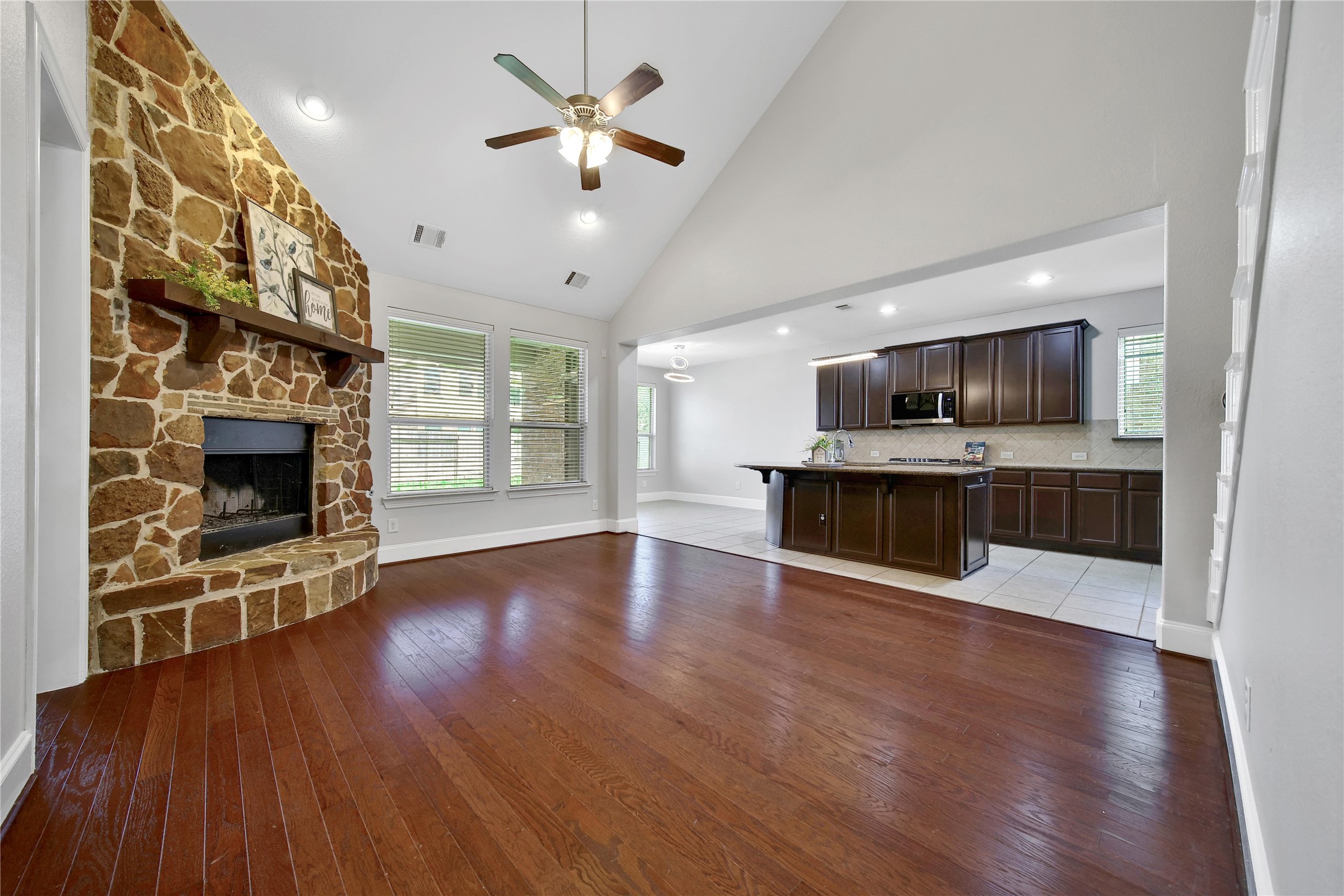 3910 Lupin Bush Lane Manvel, TX 77578 - Photo 11 of 30 an empty room with wooden floor fireplace cabinet and a flat screen tv