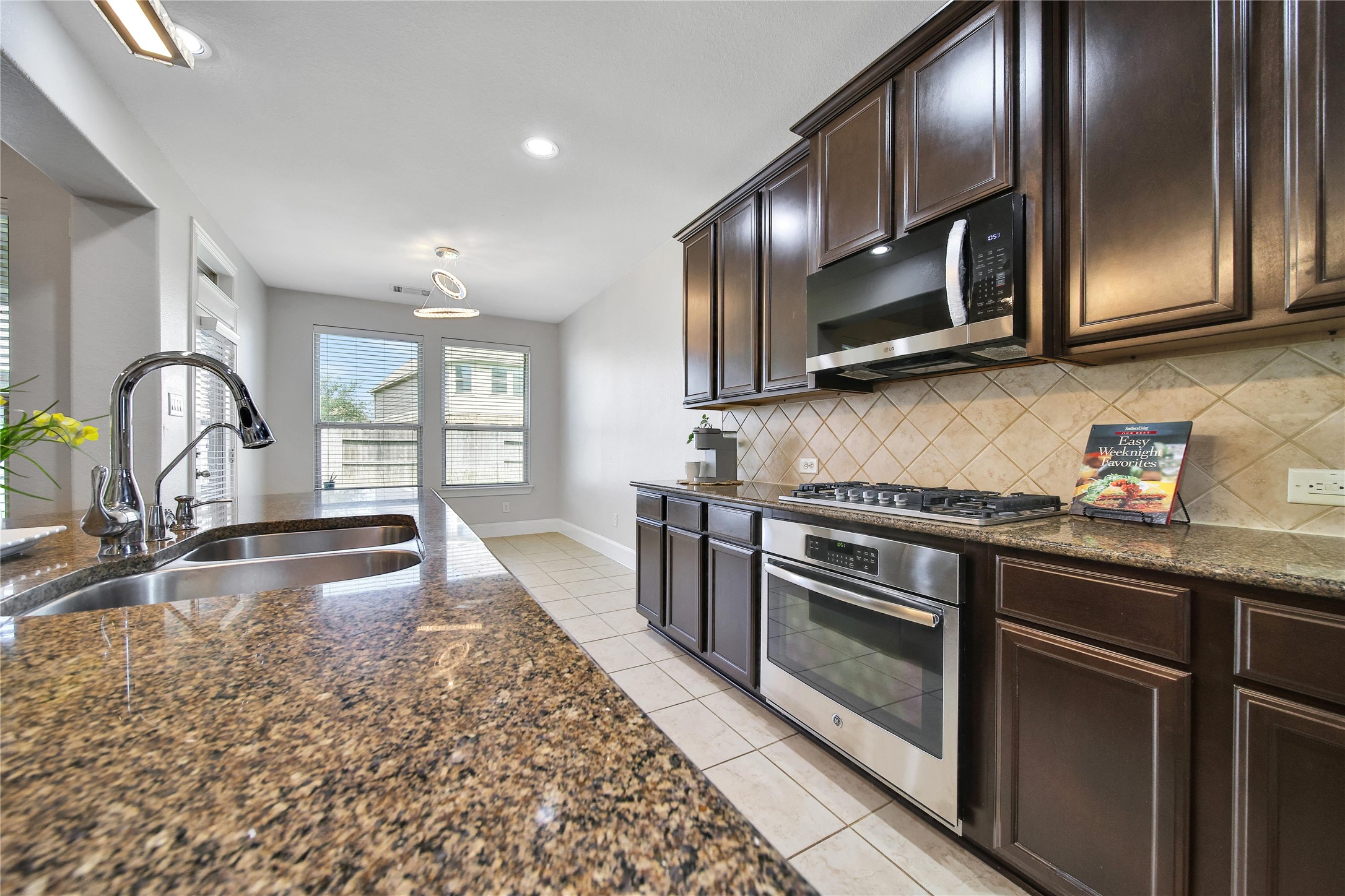 3910 Lupin Bush Lane Manvel, TX 77578 - Photo 16 of 30 a kitchen with stainless steel appliances granite countertop a stove and a sink with granite countertops