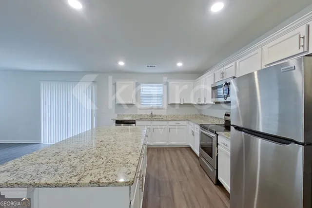 a kitchen with a refrigerator a sink and wooden cabinets
